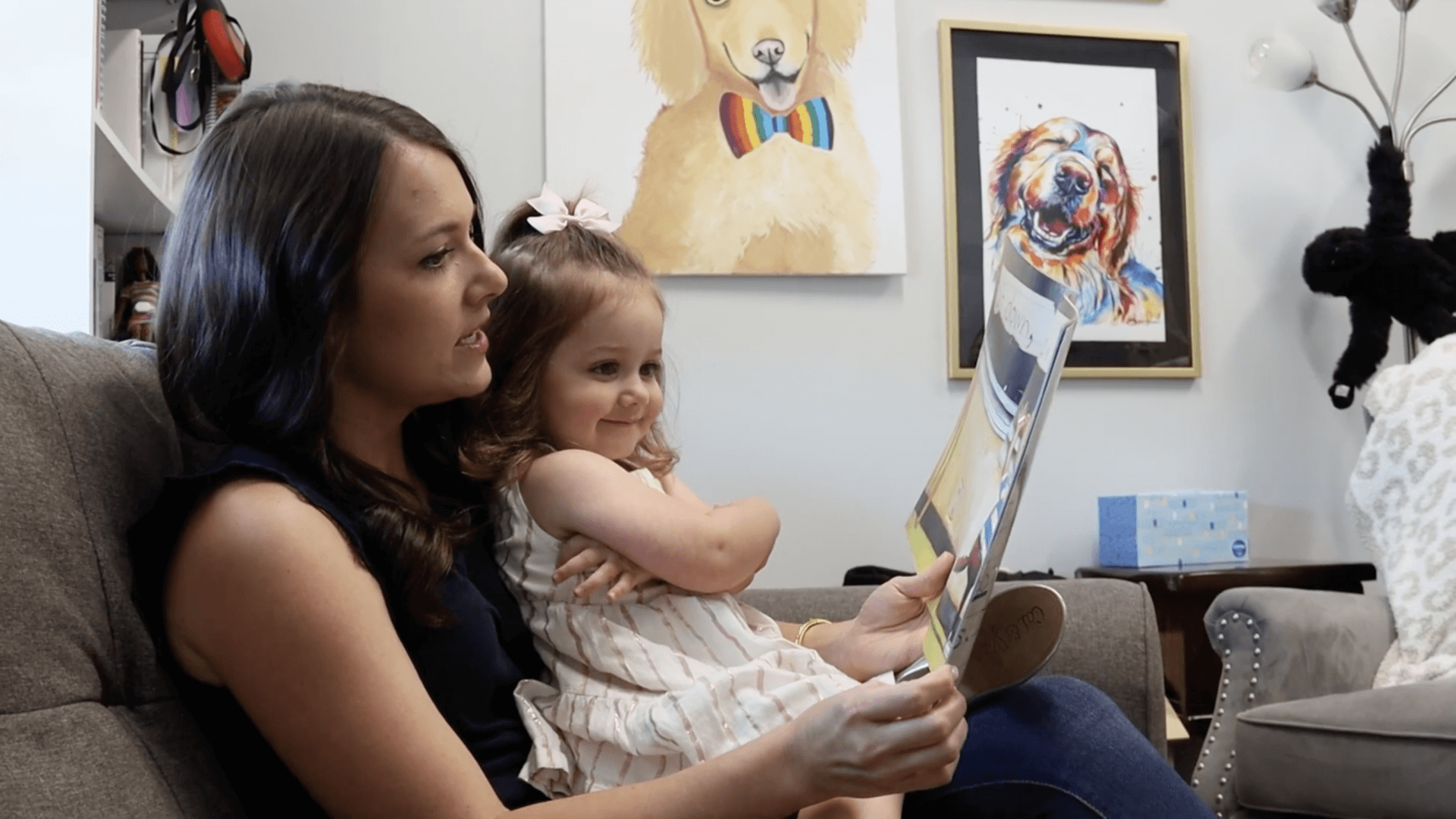 Woman reading a book to a young girl.