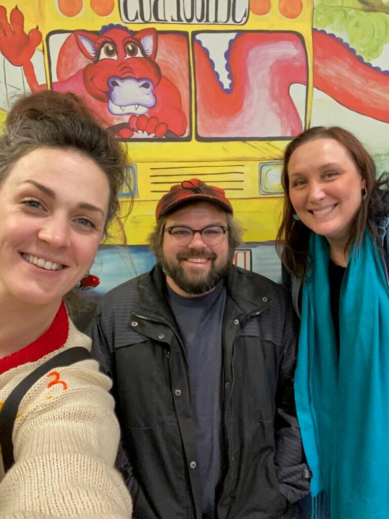 A selfie with three people smiling