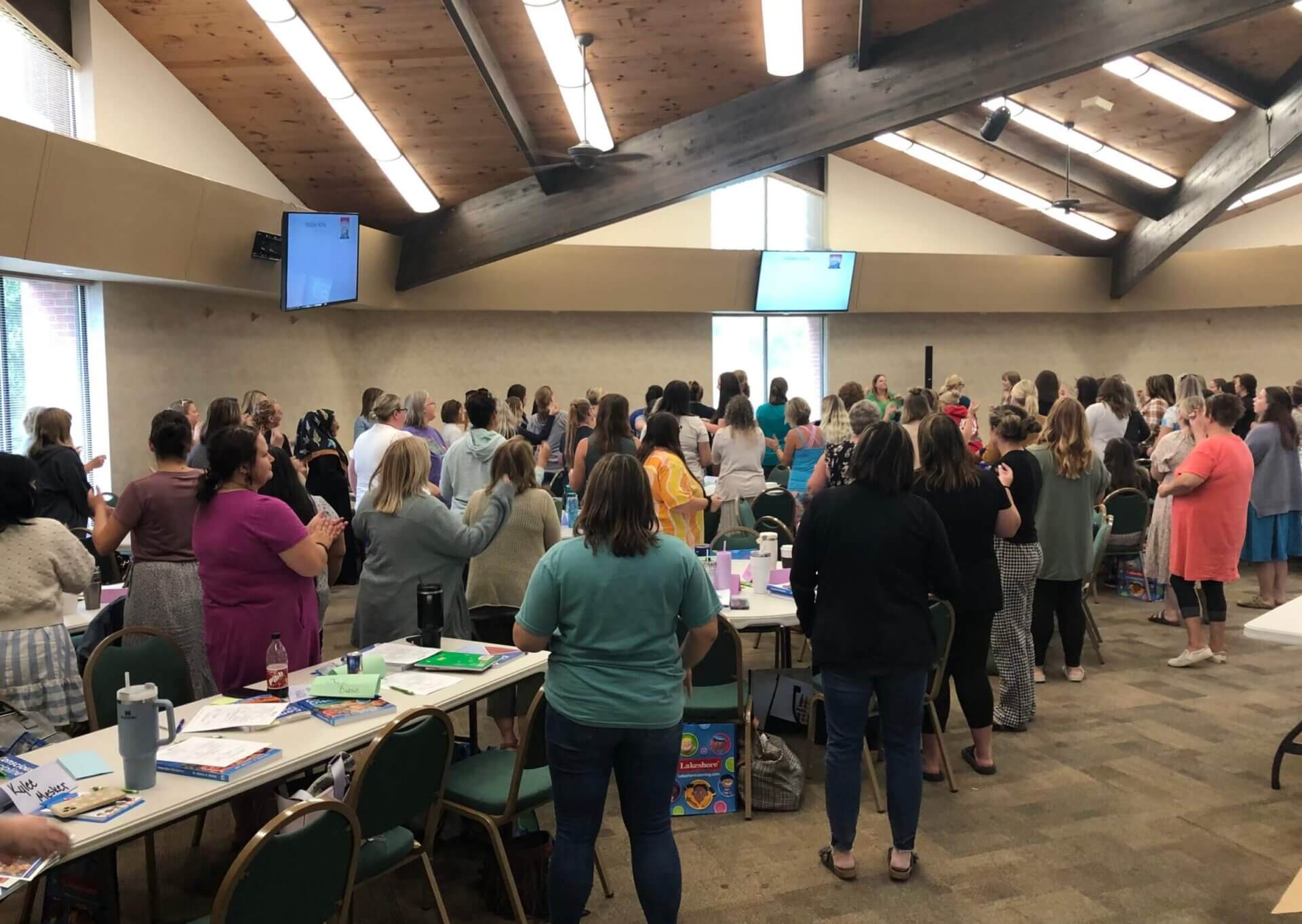 Dozens of conscious discipline training participants are standing facing away from the camera.