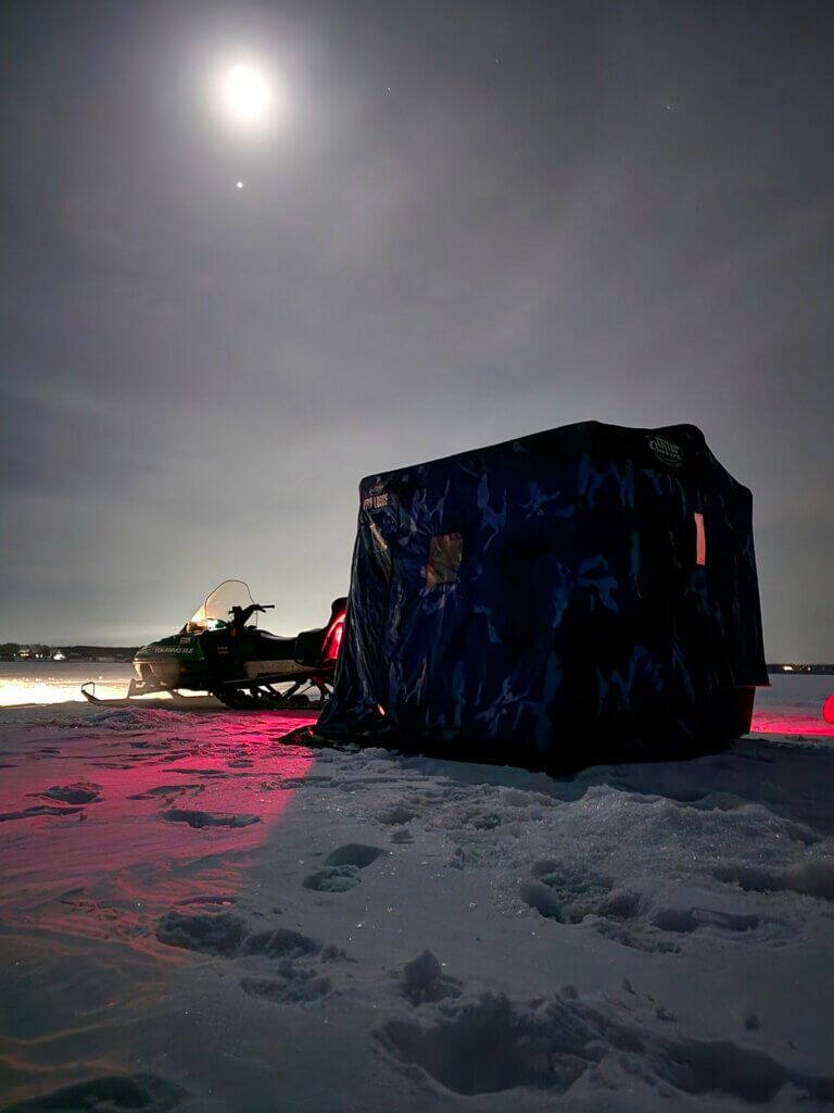 ice house on a lake with a snowmobile