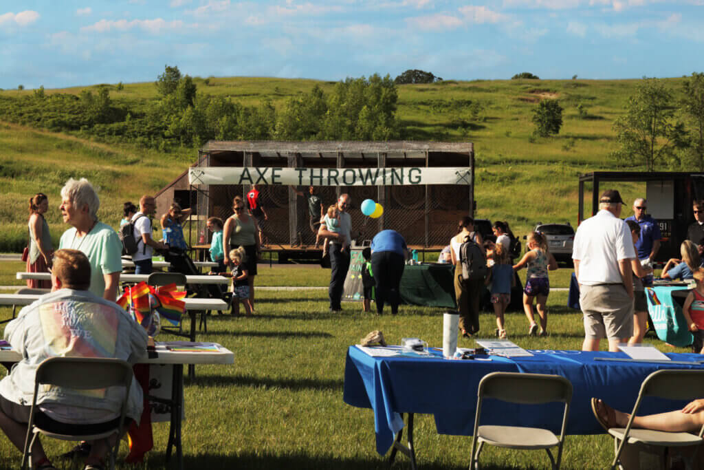 Hello Neighbor event outdoors with an axe throwing booth.