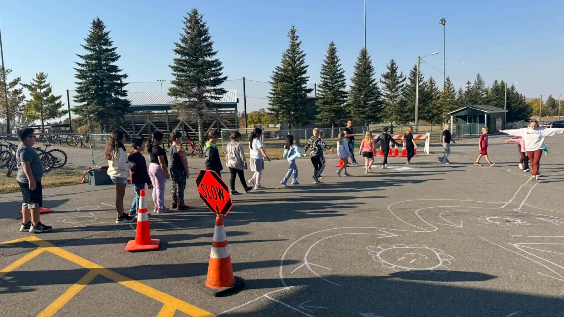 Mallory leading a line of children on a chalk path.